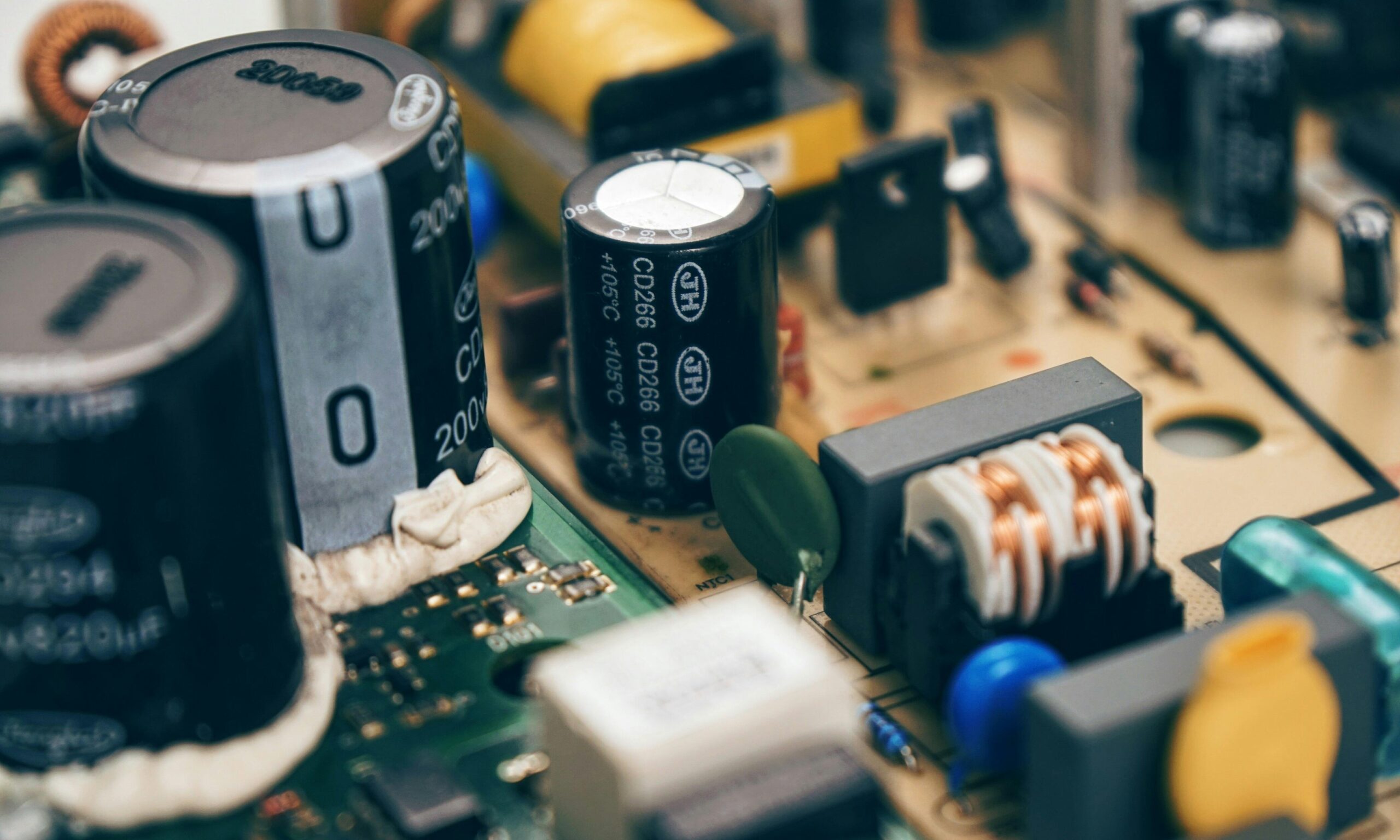 Detailed close-up of capacitors and components on a circuit board, showcasing electronic technology.